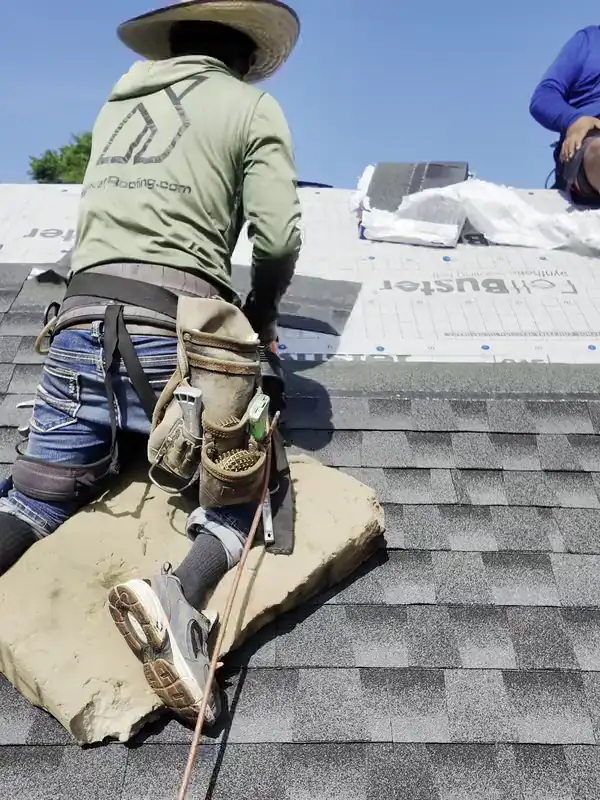 A Hisway roofer nailing new shingles over fresh underlayment