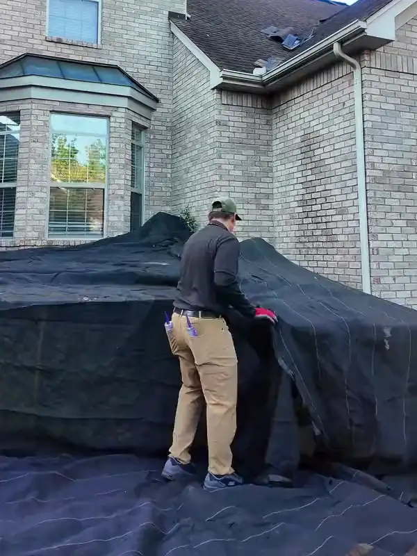 A Hisway project manager pulling tarps over the yard in front of the home